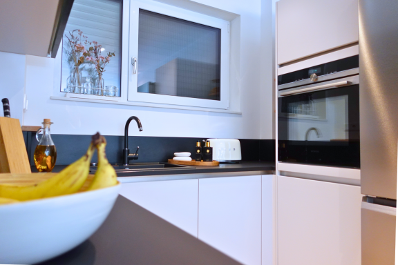 Minimalistische Kücheneinrichtung mit klaren Linien und modernen Geräten.